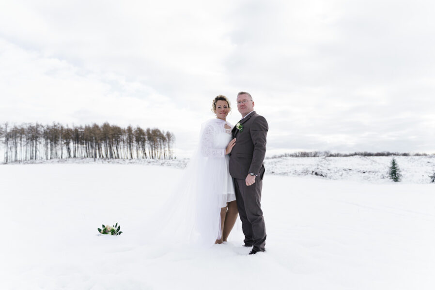 Braut mit Schleier im Pulverschnee